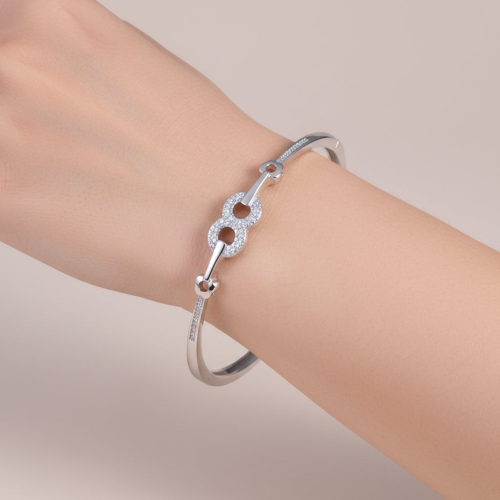 Silver bracelet with intricate design on a light wooden surface